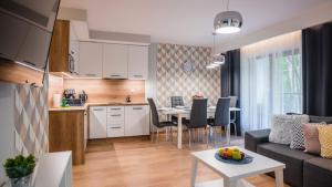 cocina y sala de estar con sofá y mesa en Trevilles Apartamenty - Green Hills, en Szklarska Poręba