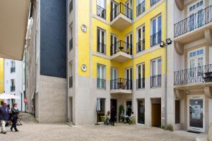 a yellow building with people walking in front of it at Cardosas Square Luxury Apartments by Porto City Hosts in Porto
