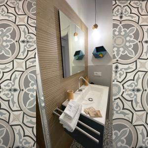 W łazience znajduje się umywalka i lustro. w obiekcie White Wall luxury rooms Scala dei turchi w mieście Realmonte