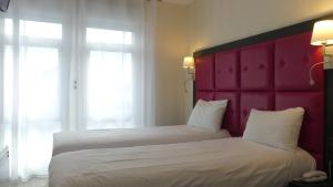 Postel nebo postele na pokoji v ubytování Logis Hôtel Saint Guirec Et De La Plage