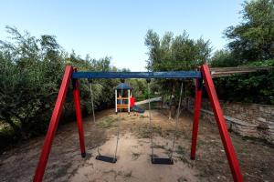 a playground with a swing set in a yard at Koroni Village in Koroni