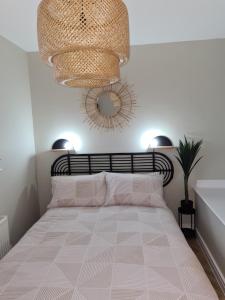 Schlafzimmer mit einem Bett und einem Kronleuchter in der Unterkunft Modern 1 bed apartment next to beach and golf course in Llanelli