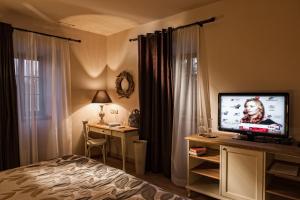 - une chambre avec un lit et une télévision sur un bureau dans l'établissement B&B Dvor Tacen, à Ljubljana