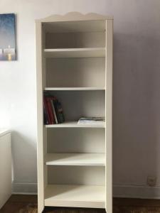 a white book shelf with books in it at Maison chaleureuse in Gilly