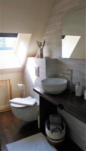La salle de bains est pourvue d'un lavabo, de toilettes et d'un miroir. dans l'établissement Maison de contes en amoureux, à Taden
