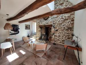 a large living room with a stone fireplace at Maison de contes en amoureux in Taden