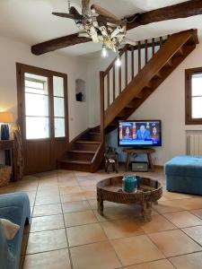 een woonkamer met een trap en een tv bij La maison du Château in Esparron-de-Verdon