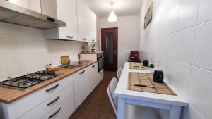 uma cozinha com armários brancos e um forno com placa de fogão em Da Vinci's House, a due passi dalla Reggia em Venaria Reale