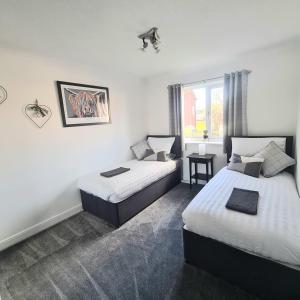 a hotel room with two beds and a window at Levenside Holiday Apartment, Balloch, Loch Lomond in Balloch