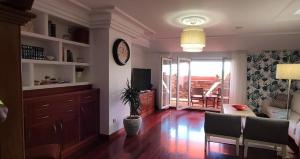 a living room with a clock on the wall at Atico C&E Cambados in Cambados