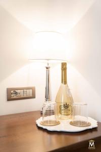 una botella de vino en una mesa con una lámpara en Museum Center Luxury, en Reggio Calabria