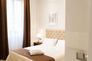 Un dormitorio con una cama blanca y una ventana. en Museum Center Luxury, en Reggio Calabria