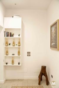 Habitación con paredes blancas y estante con jarrones. en Museum Center Luxury, en Reggio Calabria