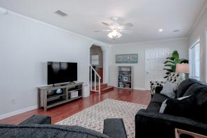 un soggiorno con un divano e una TV di Beachside snowbird escape with fenced yard & washer/dryer - walk to beach access a Baptist Medical Center/Beaches Heliport