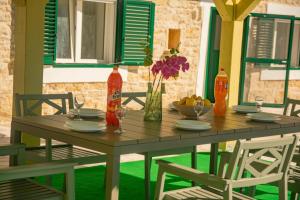 a wooden table with chairs and vases on it at Rural Villa Olive Krka- 30 min from sea, private pool, free parking, wifi, family friendly, park Krka 10 min in Ljubotić