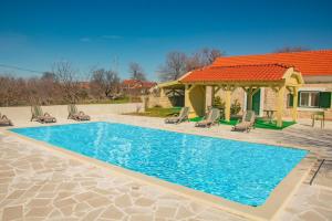 a swimming pool with chairs and a gazebo at Rural Villa Olive Krka- 30 min from sea, private pool, free parking, wifi, family friendly, park Krka 10 min in Ljubotić