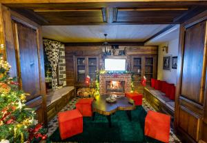 a living room with a fireplace and a christmas tree at Bujtina Oxhaku in Korçë