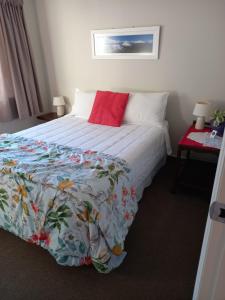 a bedroom with a bed with a red pillow at b&b @ fynnz in Turangi