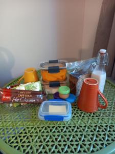 b&b @ fynnz في تورانجي: طاولة خضراء مع بعض الطعام وزجاجة من الحليب