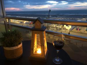 a glass of wine on a table with a view of a beach at LECOMTE Zeedijk Blankenberge in Blankenberge