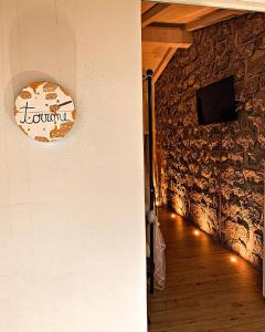 una stanza con un muro in pietra con un orologio sul muro di B&B Anastasia a Santa Teresa di Gallura