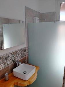 a bathroom with a white sink and a mirror at suite room malpensa b&b in Cardano al Campo