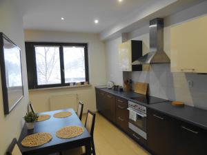 a kitchen with a table and a dining room at Apartamenty Arkadia by VisitWarsaw Apartments in Warsaw