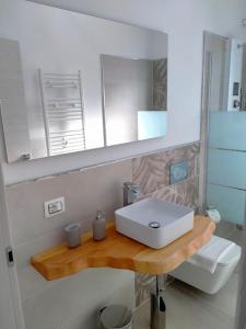 een badkamer met een witte wastafel en een spiegel bij suite room malpensa b&b in Cardano al Campo