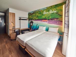 um quarto com uma cama grande e um quadro na parede em B&B HOTEL Fort-de-France em Fort-de-France