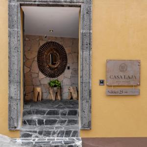 een deur naar een gebouw met een muur met een spiegel bij Hotel Boutique Casa Laja in San Miguel de Allende