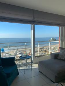 ein Wohnzimmer mit Couch und Blick aufs Meer in der Unterkunft MIRAMAR Zeedijk 168 Blankenberge in Blankenberge