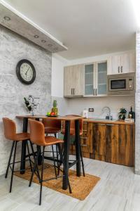 een keuken met een tafel en stoelen en een klok aan de muur bij Apartman Despot in Banja Koviljača