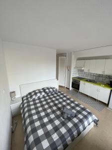 ein Schlafzimmer mit einem karierten Bett in einer Küche in der Unterkunft Cosy studio with pool in Port d'Alcúdia