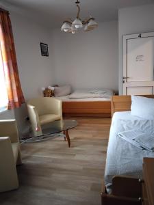 a bedroom with a bed and a couch and a chair at Pension Insulaner in Bremen