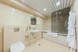 a bathroom with a toilet and a sink and a shower at Orbita Hotel in Minsk