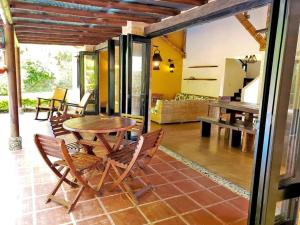 eine Terrasse mit einem Holztisch und Stühlen in einem Zimmer in der Unterkunft Fincas Panaca HERRERÍA 7 Grupo VIP in Quimbaya