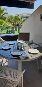 a table with plates and utensils on a patio at Penthouse 86 LA ZENIA boulevard in Orihuela