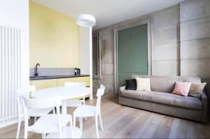 a living room with a couch and a table and chairs at Appartamenti i Colori in Ivrea