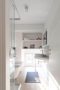 a white bathroom with a sink and a shower at Appartamenti i Colori in Ivrea