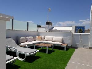 a patio with a couch and a table on a roof at Penthouse 86 LA ZENIA boulevard in Orihuela