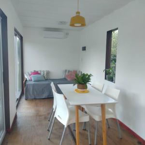 a dining room with a white table and white chairs at La irupe in Capilla del Señor