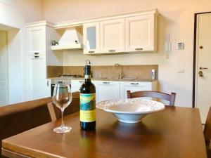 eine Flasche Wein und ein Glas auf dem Tisch in der Unterkunft Vittoria Chianti Vacations in Poggibonsi