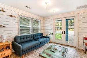 un salon avec un canapé bleu et une table dans l'établissement That Place Cottage A, à Folly Beach