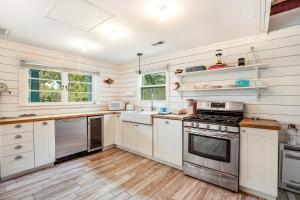 une cuisine avec des armoires blanches et une cuisinière dans l'établissement That Place Cottage A, à Folly Beach