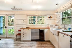 - une cuisine avec des placards blancs et un lave-vaisselle en acier inoxydable dans l'établissement That Place Cottage A, à Folly Beach