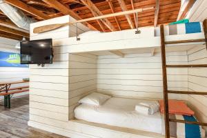 un lit superposé dans une chambre avec une télévision dans l'établissement That Place Cottage A, à Folly Beach 16 autres photos
