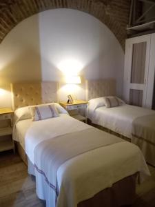 two beds in a hotel room with two lamps at Quinta da Chaminé in Ferreira do Alentejo