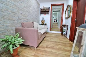 a living room with a couch and a brick wall at Casa 4 Estações in Arrifes
