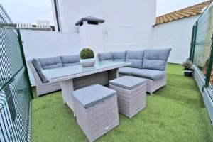 a patio with a couch and a table and chairs at Casa 4 Estações in Arrifes