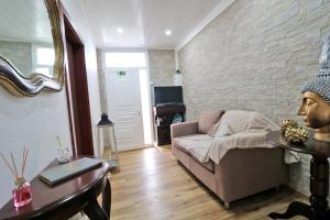 a living room with a couch and a brick wall at Casa 4 Estações in Arrifes